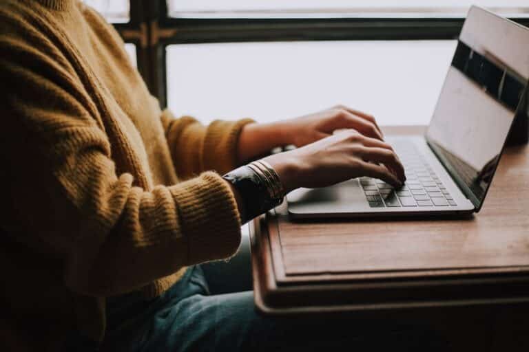 Alt text: A person using their laptop, browsing the Internet to find what is an ideal customer profile.